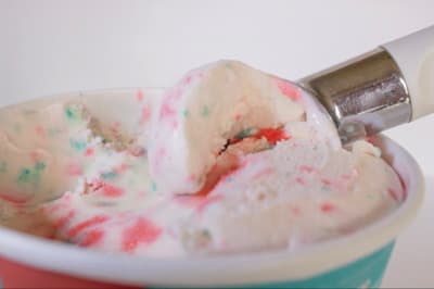 a scoop of ice cream in a cup with sprinkles