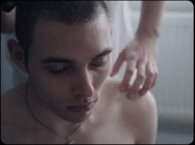 a man with no shirt on getting his hair brushed