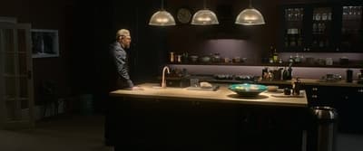 a man standing in a kitchen next to a counter