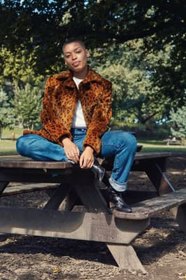 a woman sitting on a bench in a park