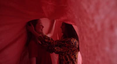 two women are standing in a red room