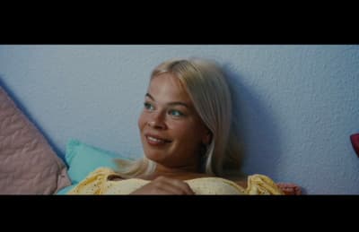 a woman laying on a bed with a blue wall behind her