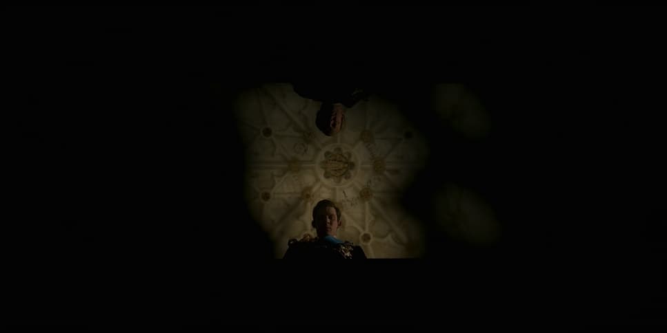 a person in a dark room with a clock on the wall