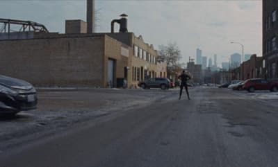 a person walking down a street in the middle of a city
