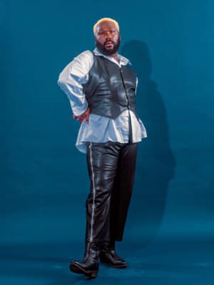 a man in a leather vest and black pants