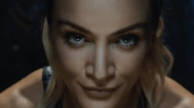 a close up of a woman's face with blue eyes