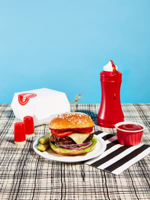 a hamburger on a plate with fries and ketchup