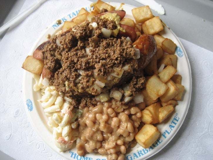 a white plate topped with lots of food on top of a table