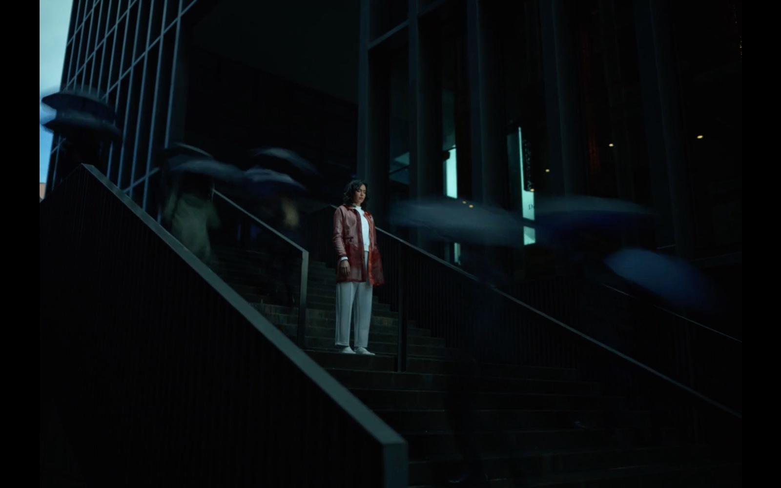 a woman standing on a set of stairs in the dark
