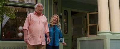 a man and a woman standing outside of a house