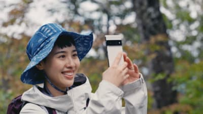 a woman in a blue hat taking a picture with her cell phone
