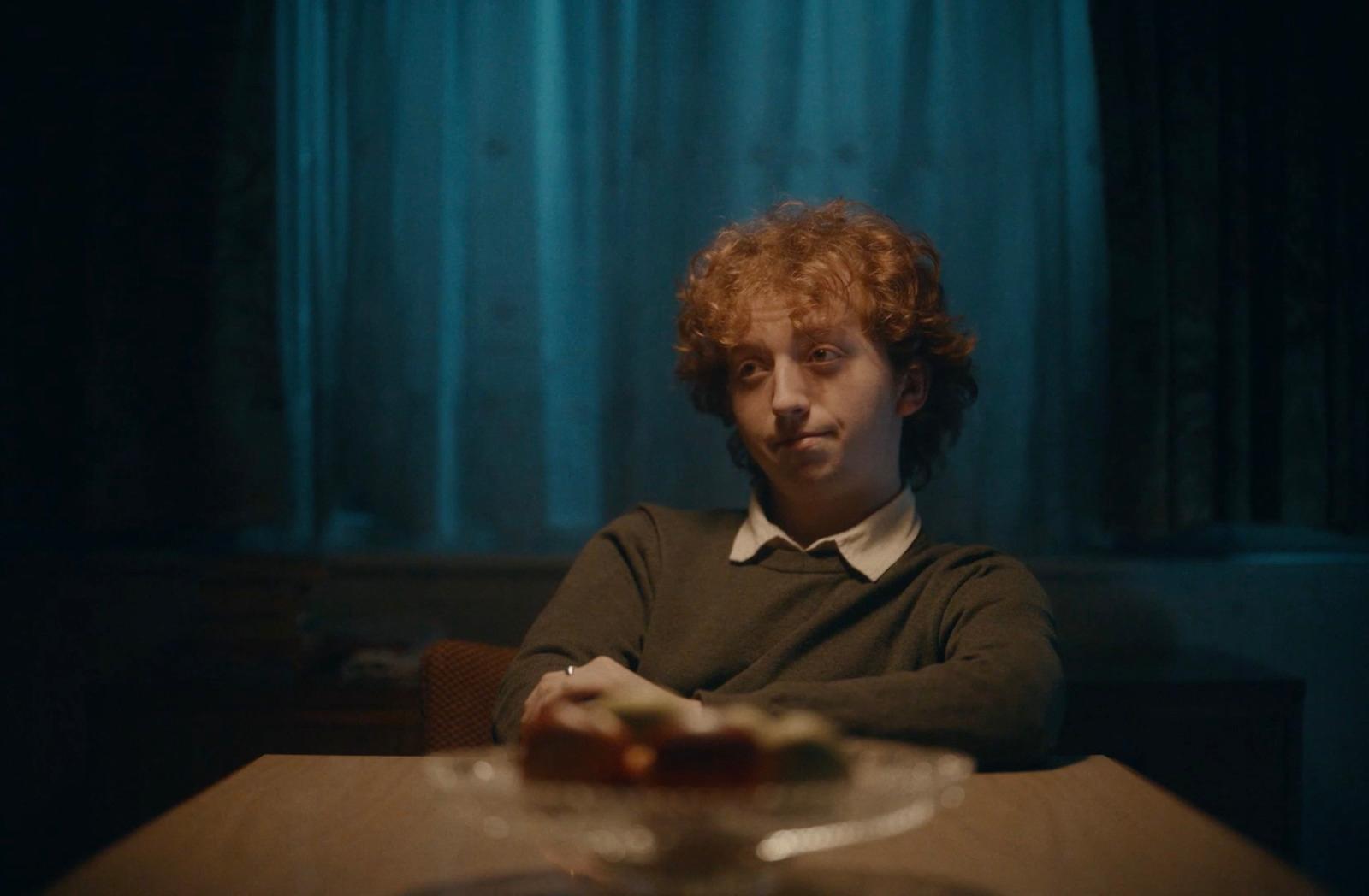 a man sitting at a table in a dark room