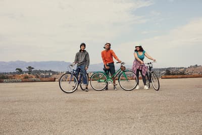 a group of three people standing next to each other on bikes