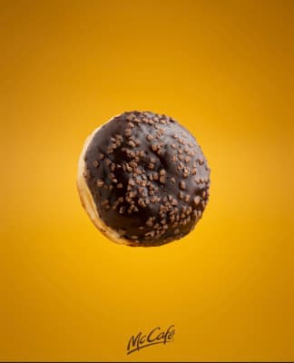 a donut with chocolate sprinkles on a yellow background