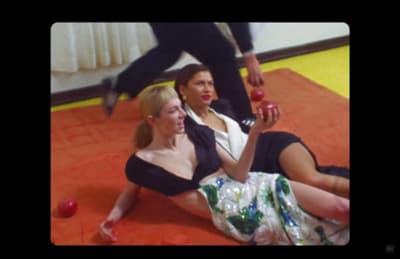 two women are sitting on the floor and one is holding an apple