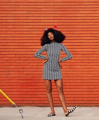 a woman standing in front of a brick wall