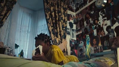a woman sitting on a bed looking at her cell phone