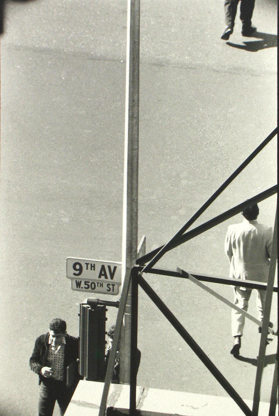 a black and white photo of a man walking down a street