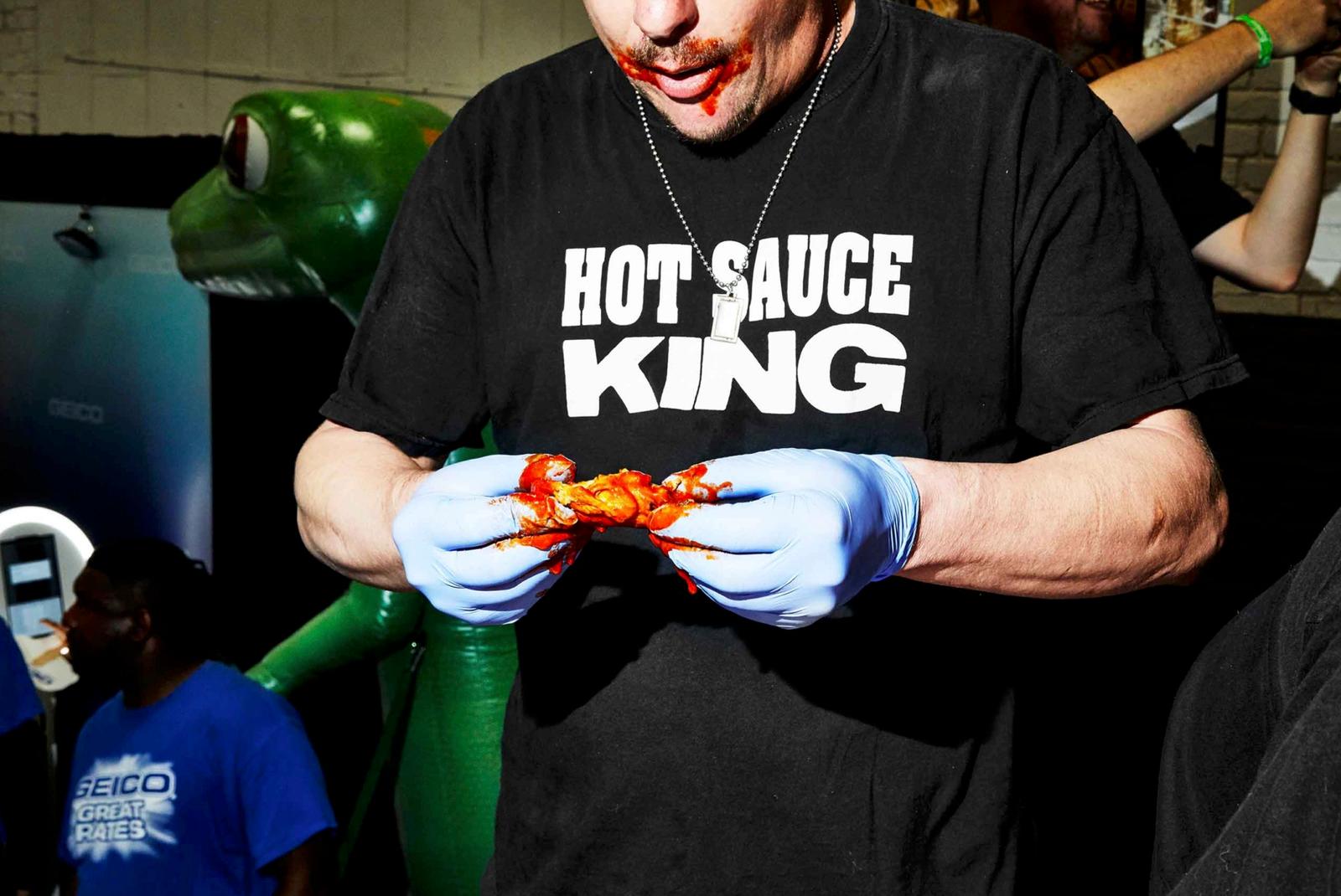 a man wearing a hot sauce king t - shirt