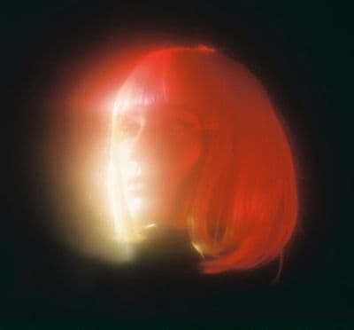 a woman with red hair and bright light shining on her face