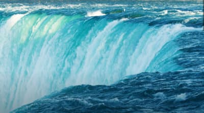 a large waterfall that is in the middle of a body of water