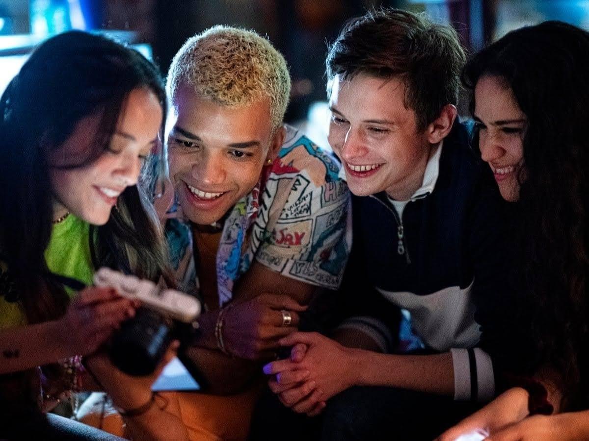 a group of young people looking at a cell phone