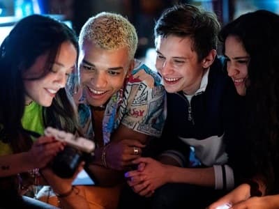a group of young people looking at a cell phone