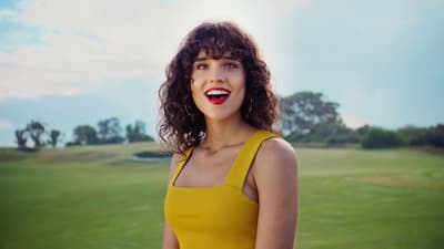 a woman in a yellow dress standing in a field