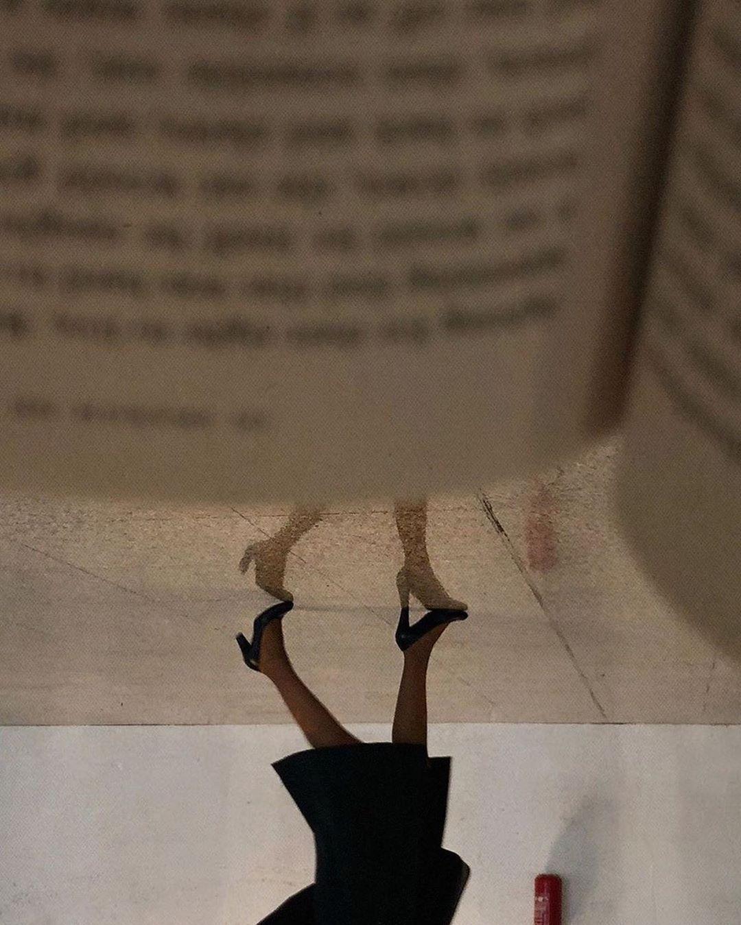 a woman in a black dress is upside down