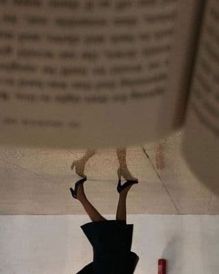 a woman in a black dress is upside down