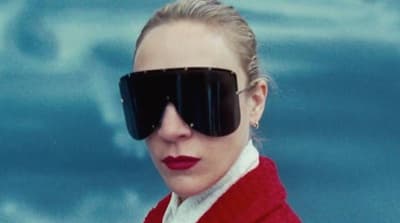 a woman in a red sweater with a blindfold on her face