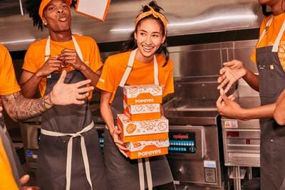 a group of people standing around each other in a kitchen