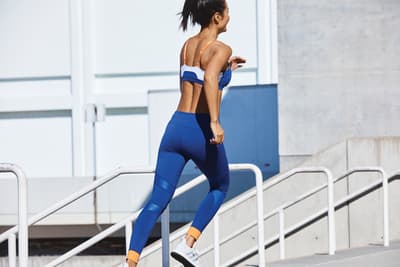 a woman riding a skateboard down a flight of stairs