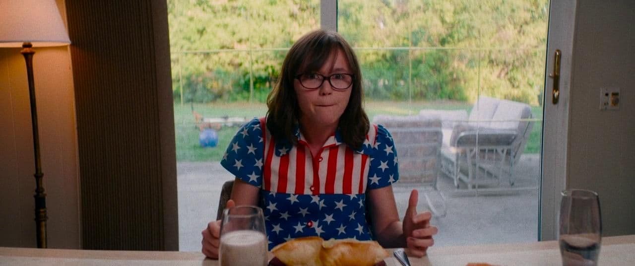 a girl sitting at a table with a plate of food