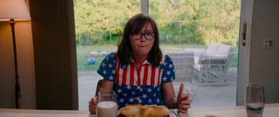 a girl sitting at a table with a plate of food