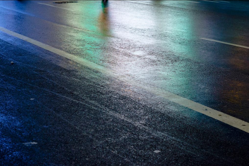 a person walking down a street at night with an umbrella
