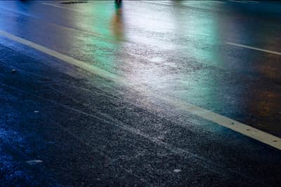 a person walking down a street at night with an umbrella