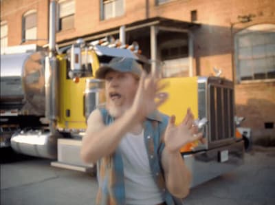 a man is standing in front of a yellow truck