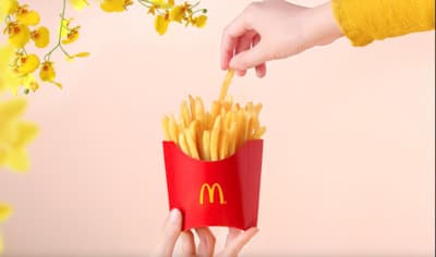 a person holding a box of french fries
