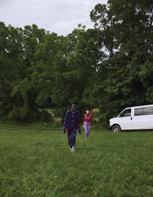 a man and a woman are walking in a field
