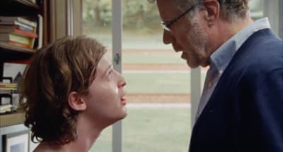 a man standing next to a woman in front of a window