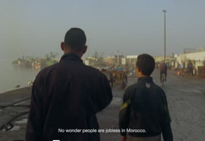a couple of men standing next to a body of water