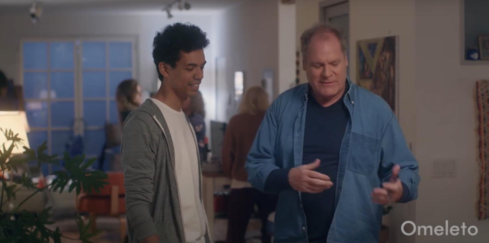 a man standing next to another man in a living room