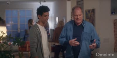 a man standing next to another man in a living room