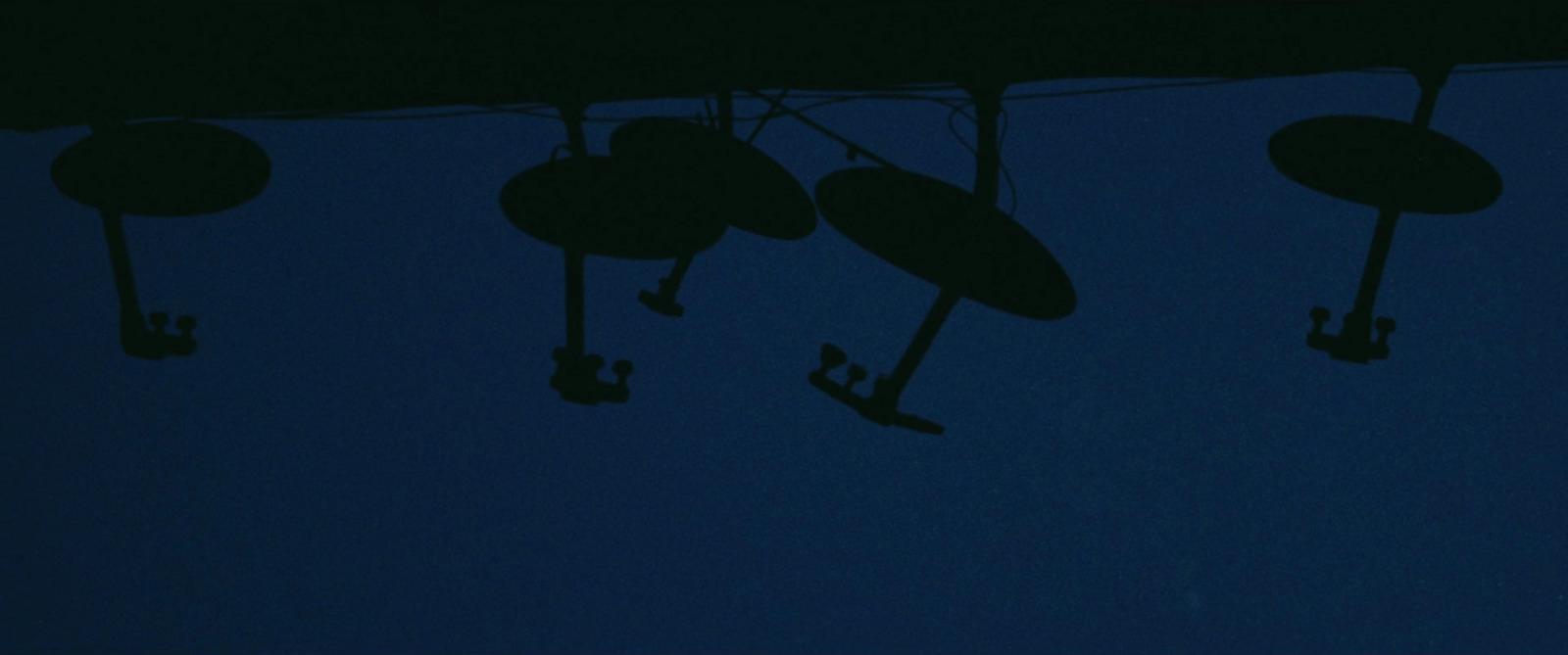 a group of umbrellas hanging from a line in the dark