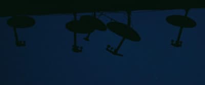 a group of umbrellas hanging from a line in the dark