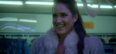 a woman in a fur coat smiling at the camera