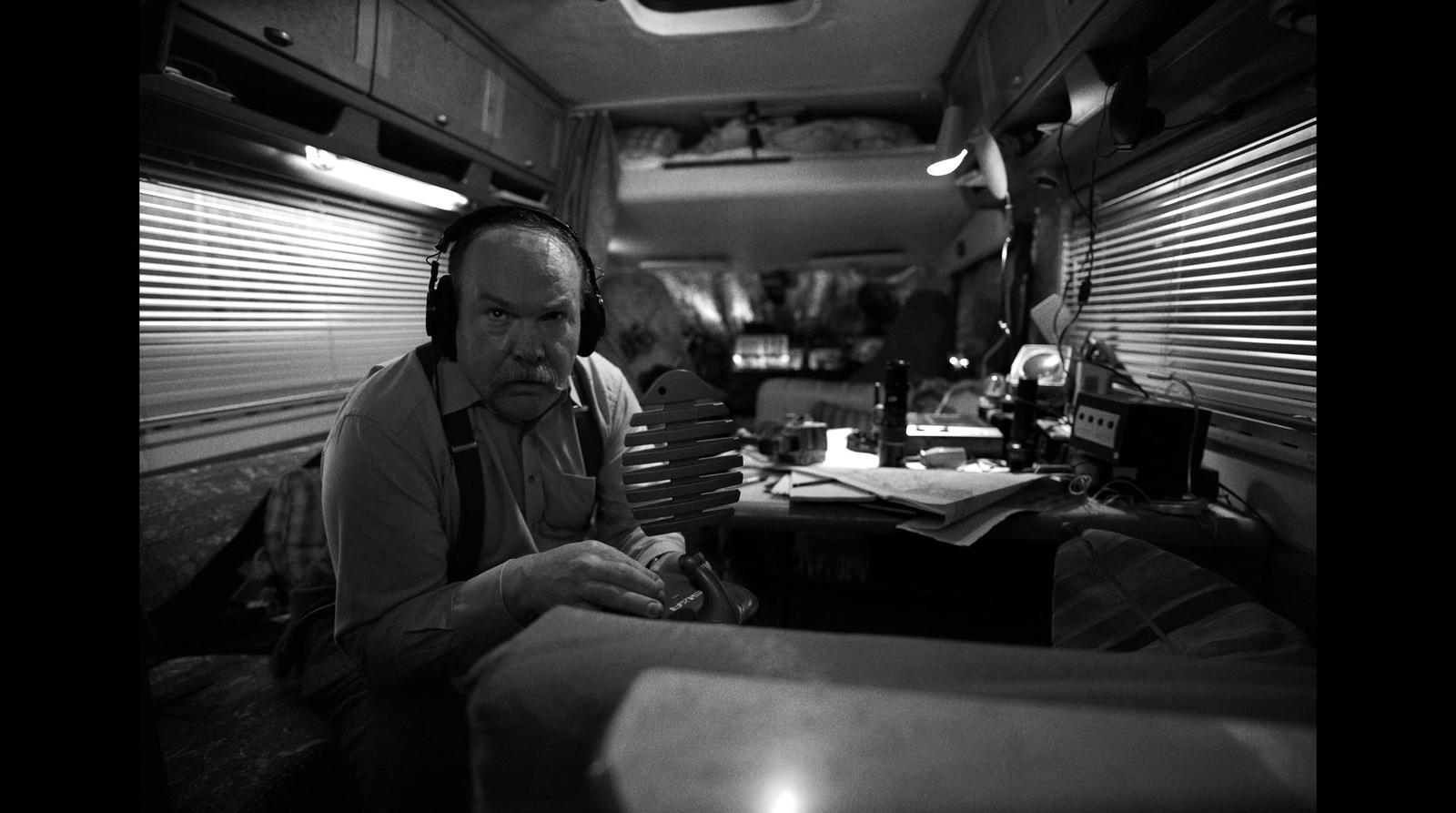 a man sitting in a vehicle with headphones on