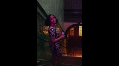 a woman in a purple dress holding a purple object
