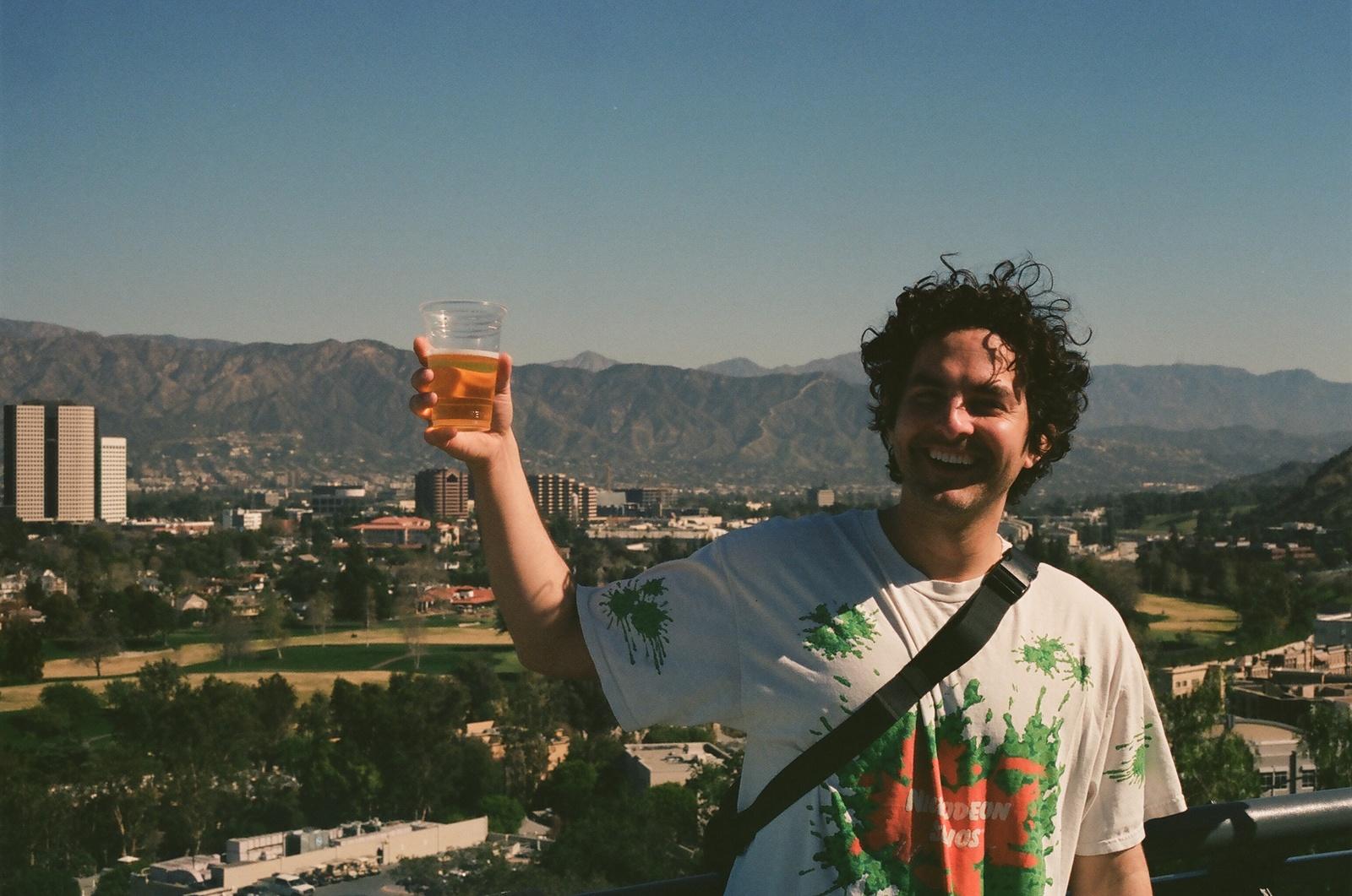 a man holding up a glass of beer